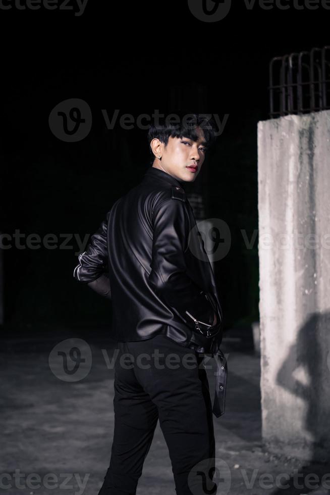 an asian man in a black leather jacket posing like a motorcycle gang photo