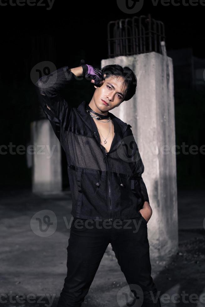 an Asian man dressed all in black and black hair posing as masculine photo