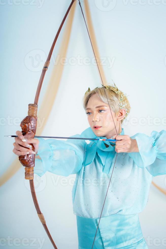 an Asian woman with blonde hair holding an arrow while wearing a blue dress photo