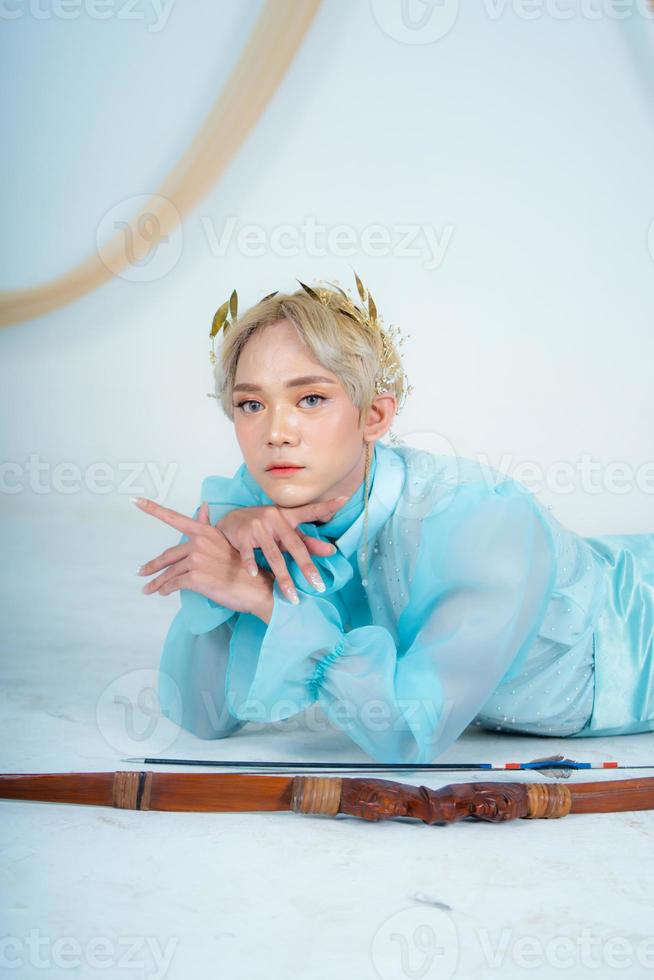 a princess in a blue dress posing on the floor with a bow photo