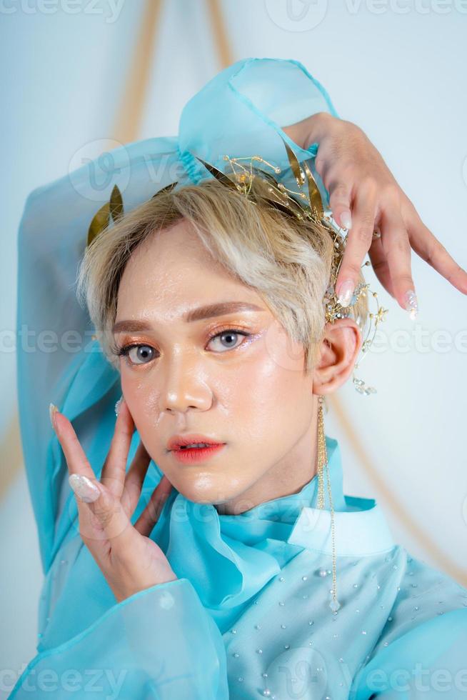 a princess with a blue dress and blonde hair posing very beautifully photo