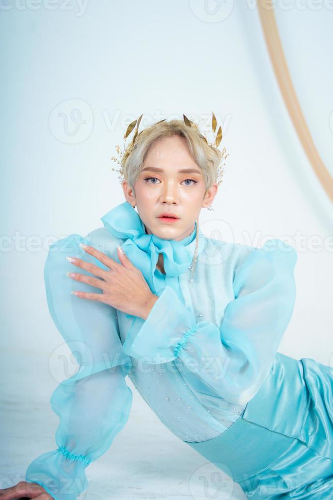 a royal princess posing with a golden crown and blonde hair very cutely photo