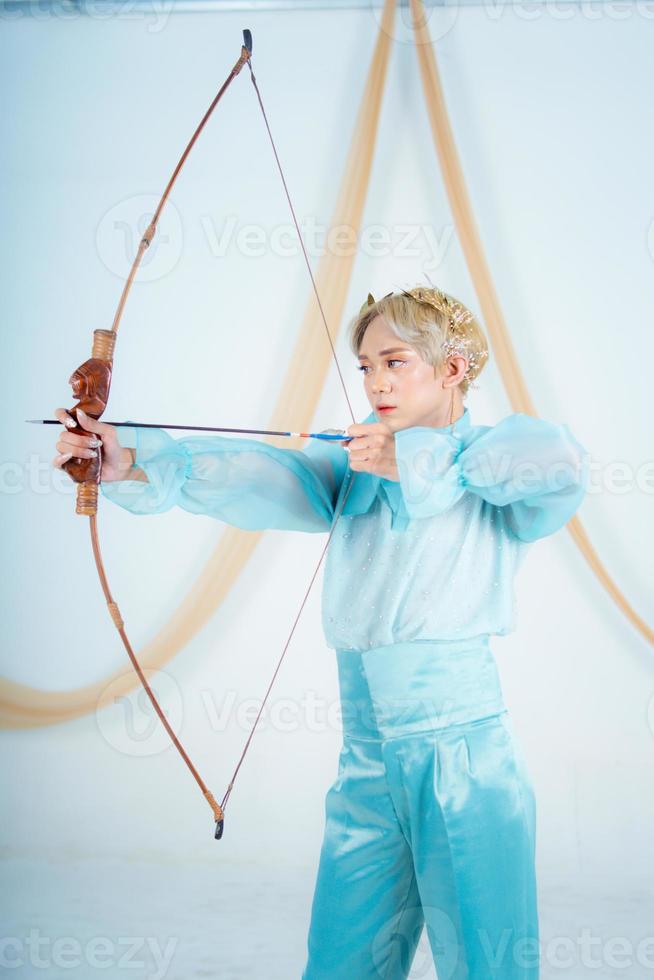 an Asian woman with blonde hair holding an arrow while wearing a blue dress photo