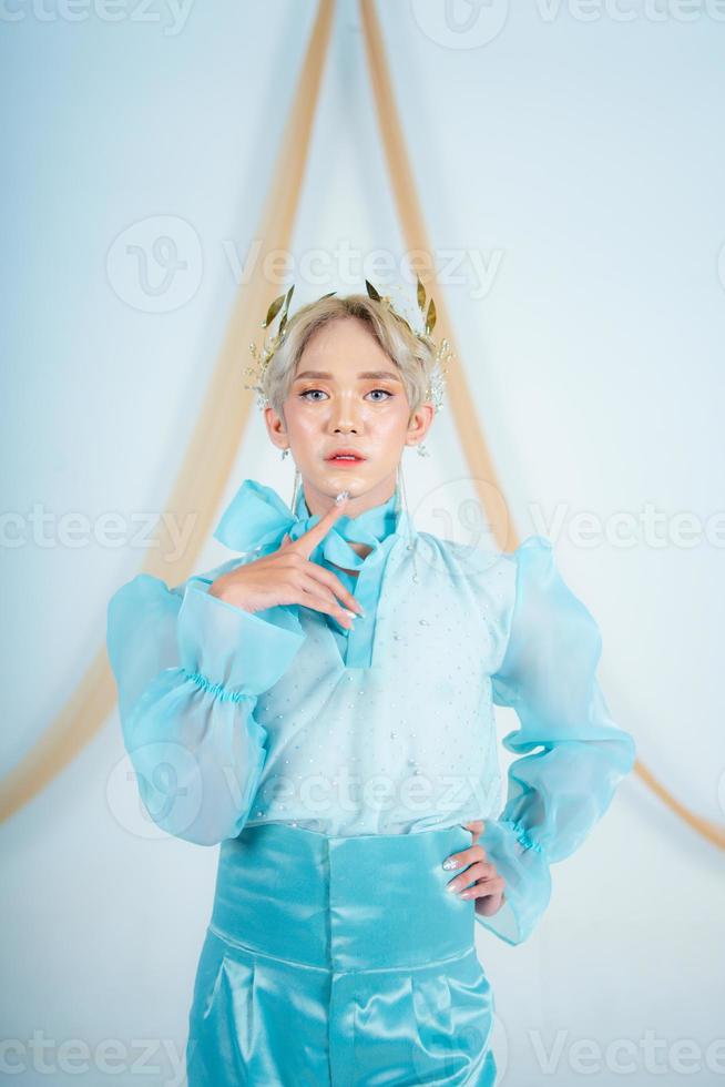 an elegant woman with blonde hair wearing a golden crown and a blue dress photo