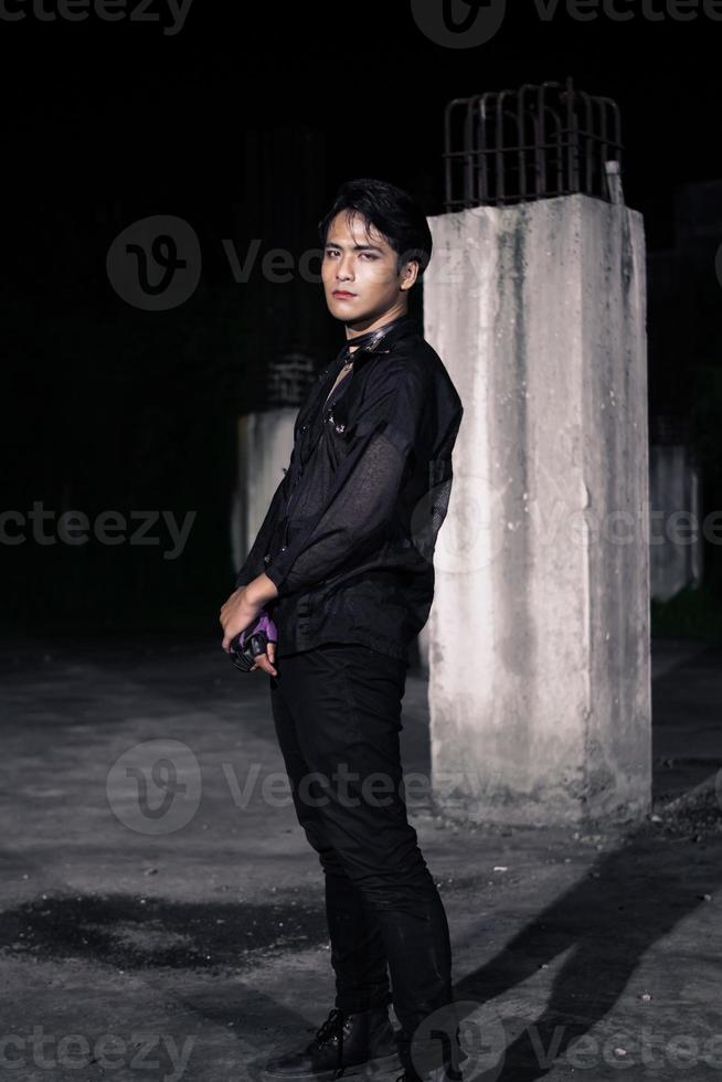 an Asian man dressed all in black and black hair posing as masculine photo