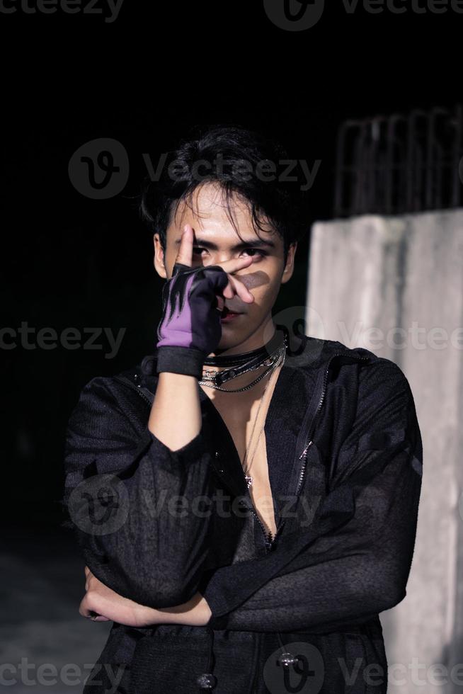 an Asian man dressed all in black and black hair posing as masculine photo