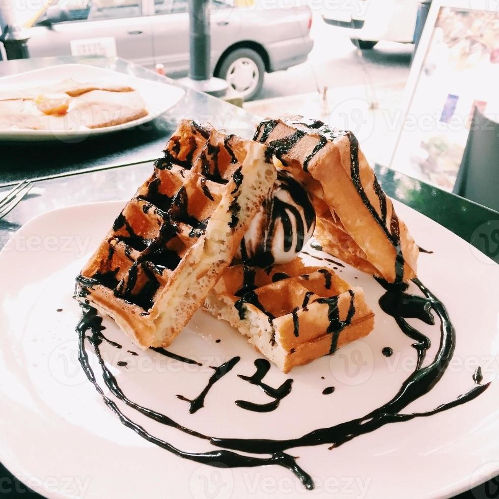 Belgian waffle with chocolate topping on white plate photo