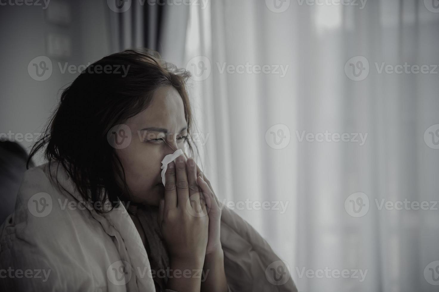 Asian sick woman sit on the sofa stay at home,The woman felt bad, wanted to lie down and rest,high fever photo