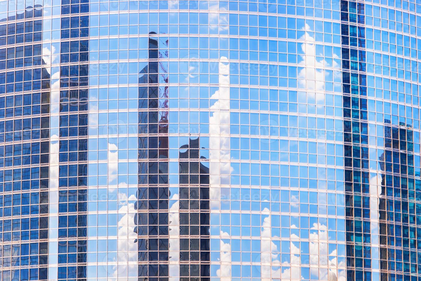 The reflection of cloud and buildings in the windows of modern office building photo