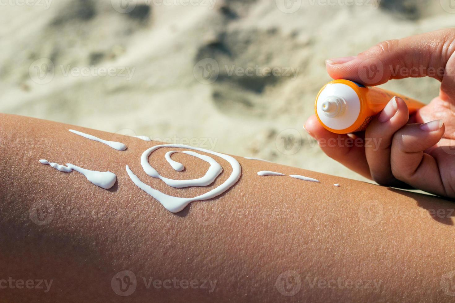 protector solar Dom dibujo loción en bronceado piernas relajante bronceado en tropical playa día festivo. mujer inferior cuerpo acostado con bloqueador solar crema en forma para piel cáncer bronceado cuidado concepto. foto