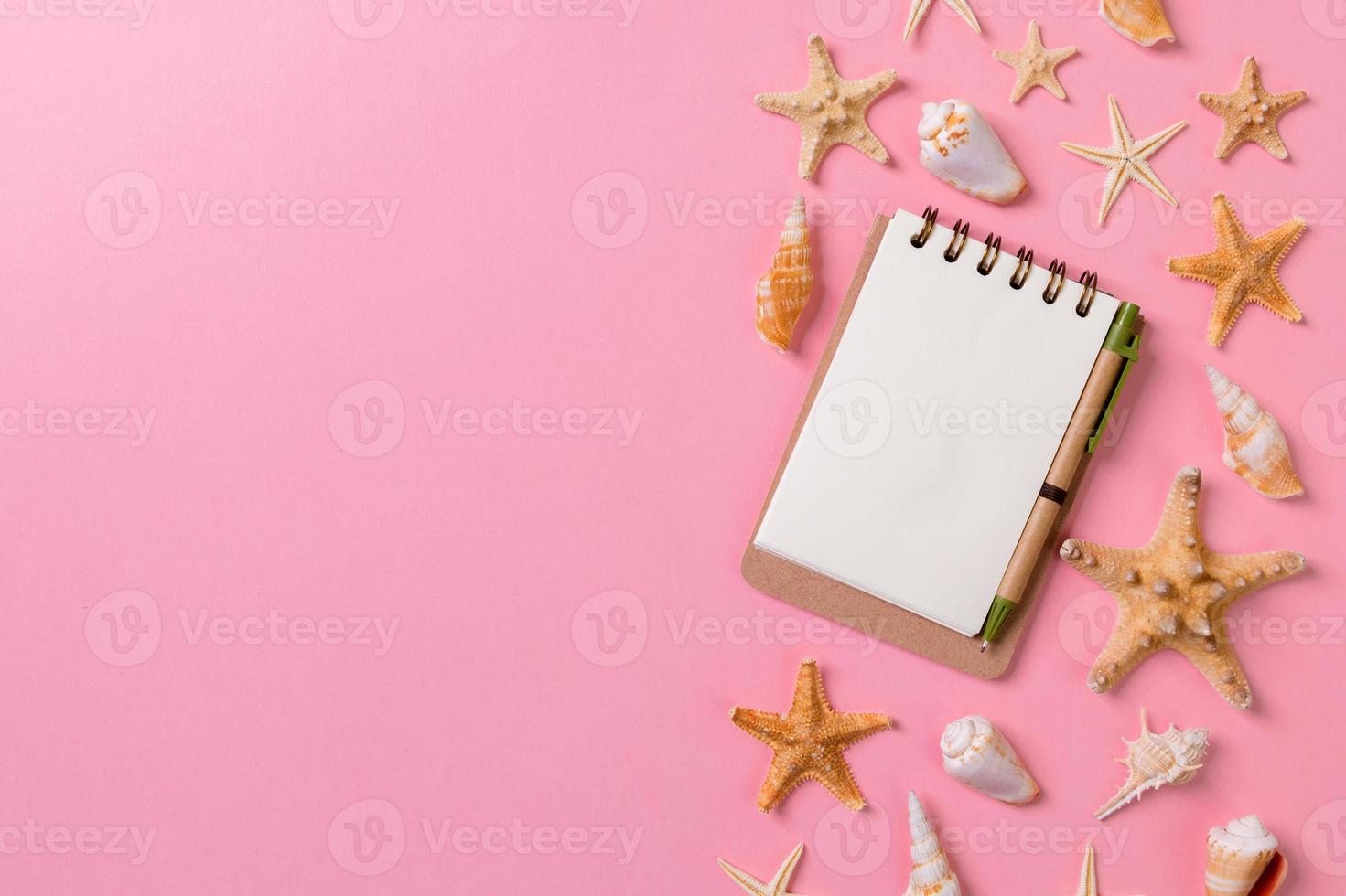 blank notebook with seashell for summer holiday pink background , Top view Flat lay concept photo