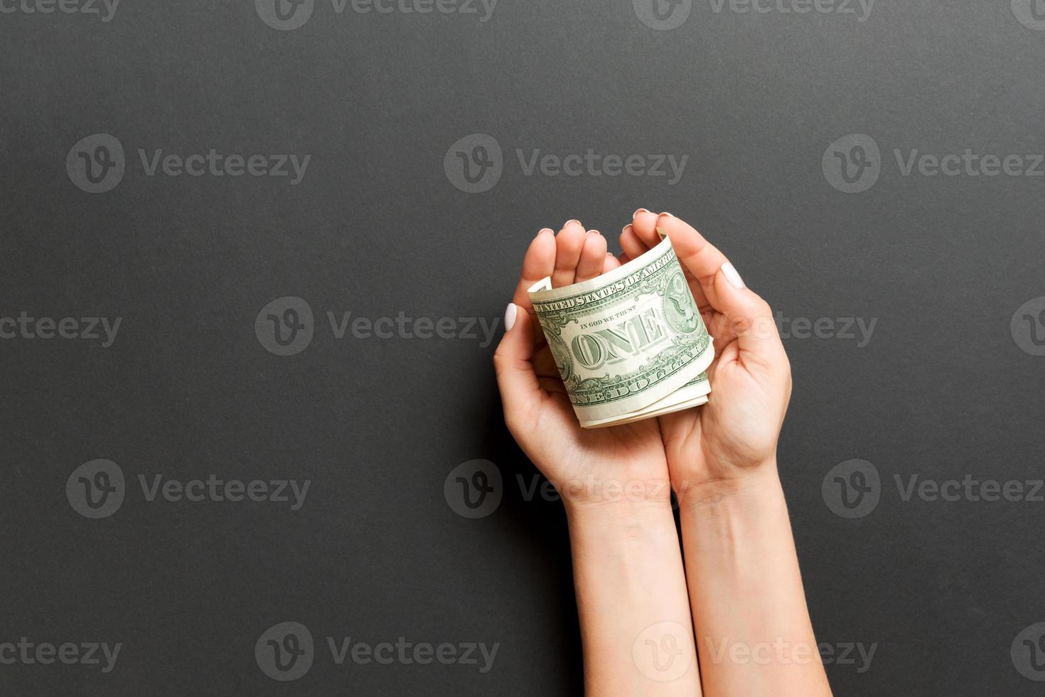 Top view of dollar banknotes in female hands on colorful background. Retirement and poverty concept photo
