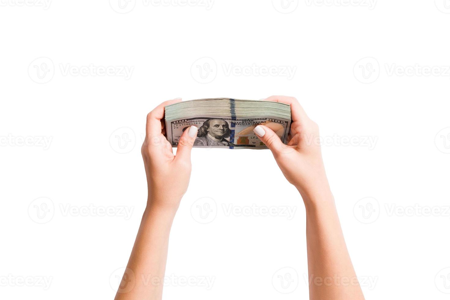 Top view of a bundle of money in female hands. Image of counting dollars on white isolated background. Tax concept photo