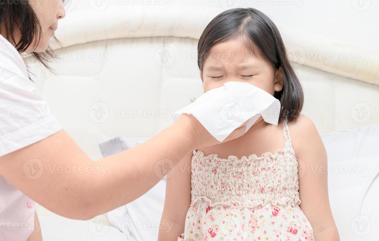 Mother teach blowing the nose by tissue. photo