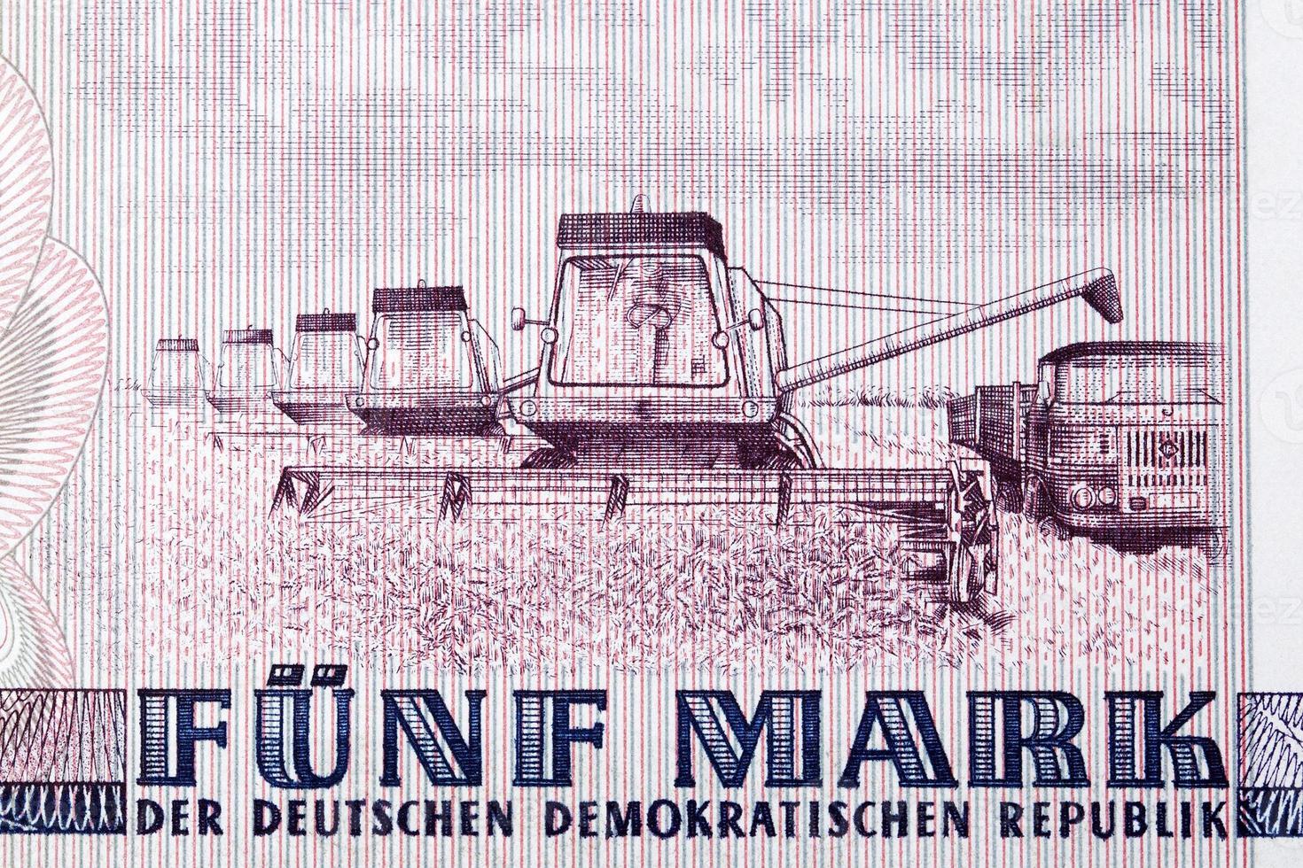 Several harvesting machines from East German money photo