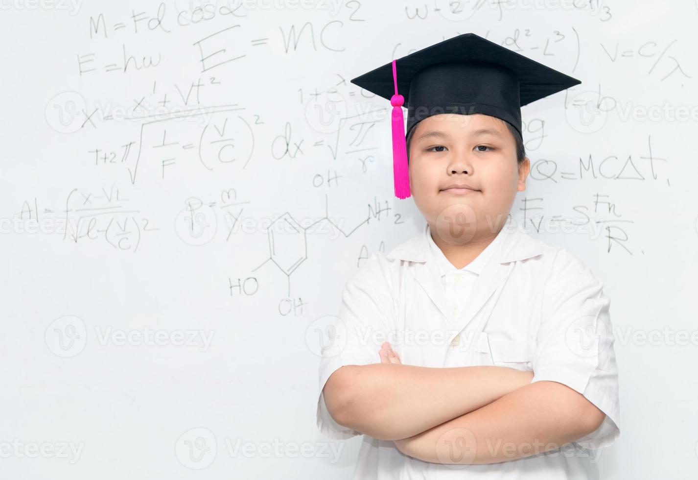scientist boy wear graduation hat on whiteborad photo