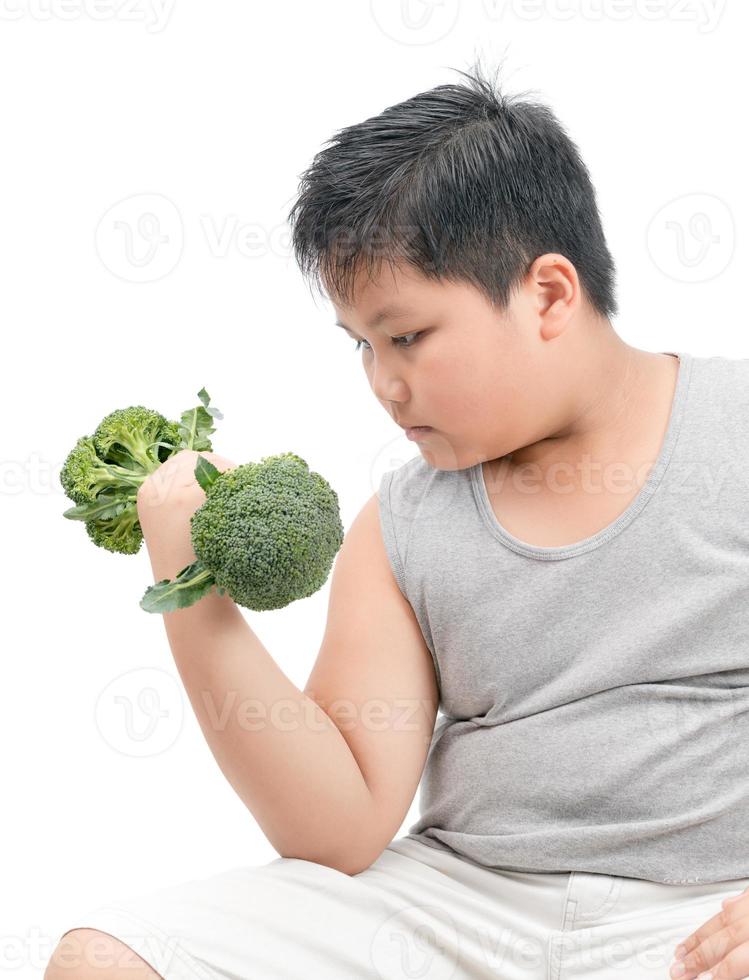 Obese fat boy holding a broccoli dumbbell isolated photo