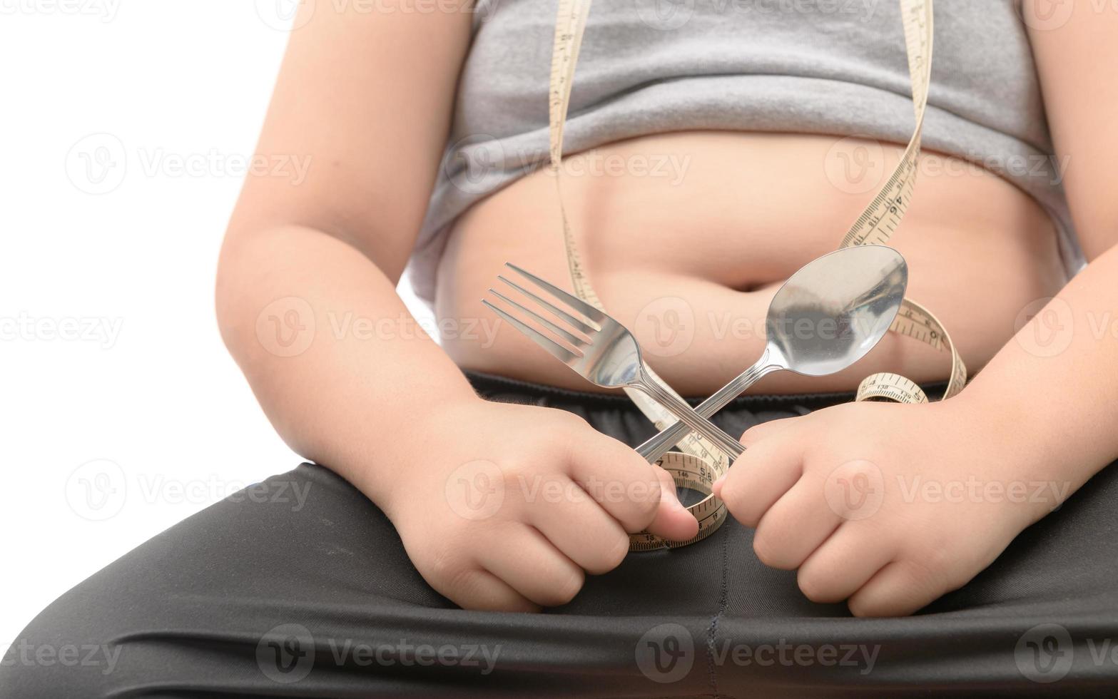 Obese fat boy holding fork and spoon isolated photo