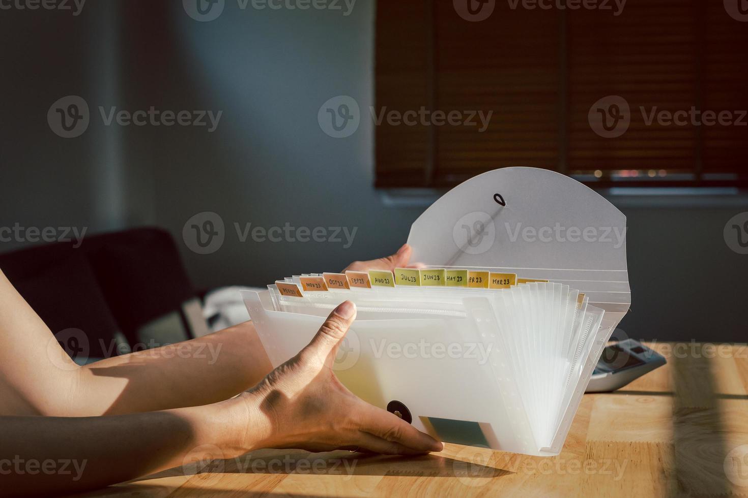 Woman hands organizing folder on a desk at home. photo