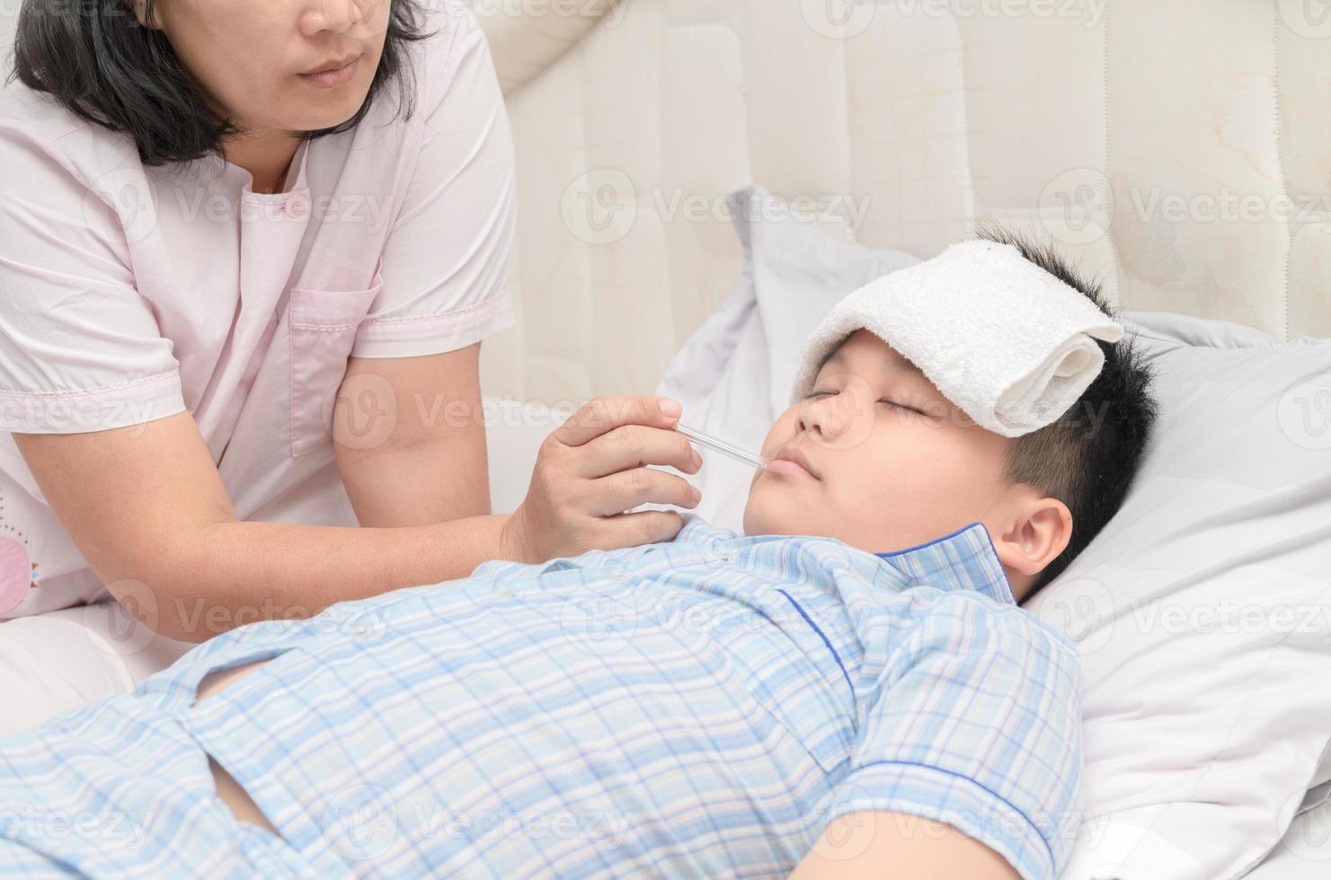 Mother checks son's temperature photo
