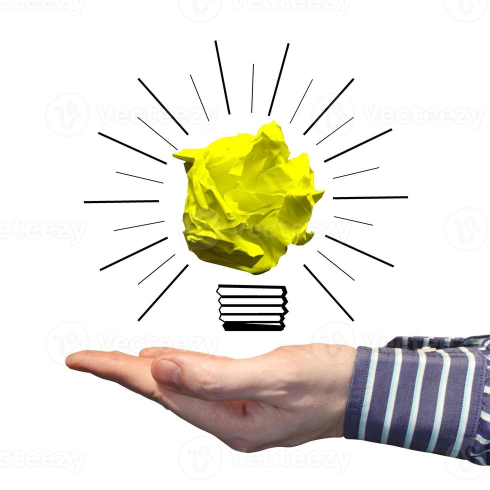 Light Bulb Icon Made with Crumpled Paper and Human Hand - Idea, Creativity Concept photo