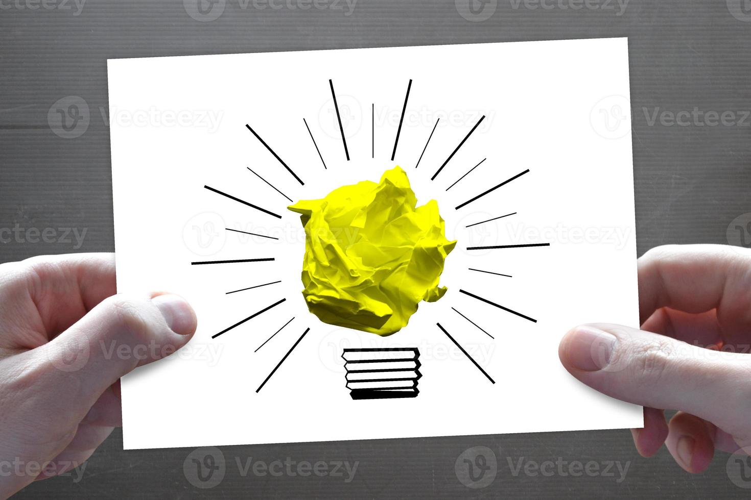 Light Bulb Icon Made with Crumpled Paper and Human Hands - Idea, Creativity Concept photo
