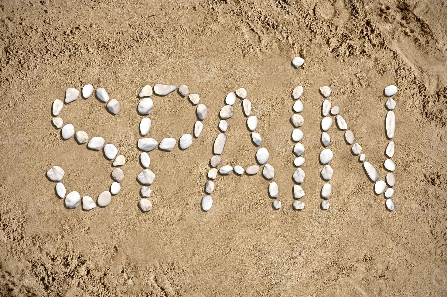 España - palabra hecho con piedras en arena foto