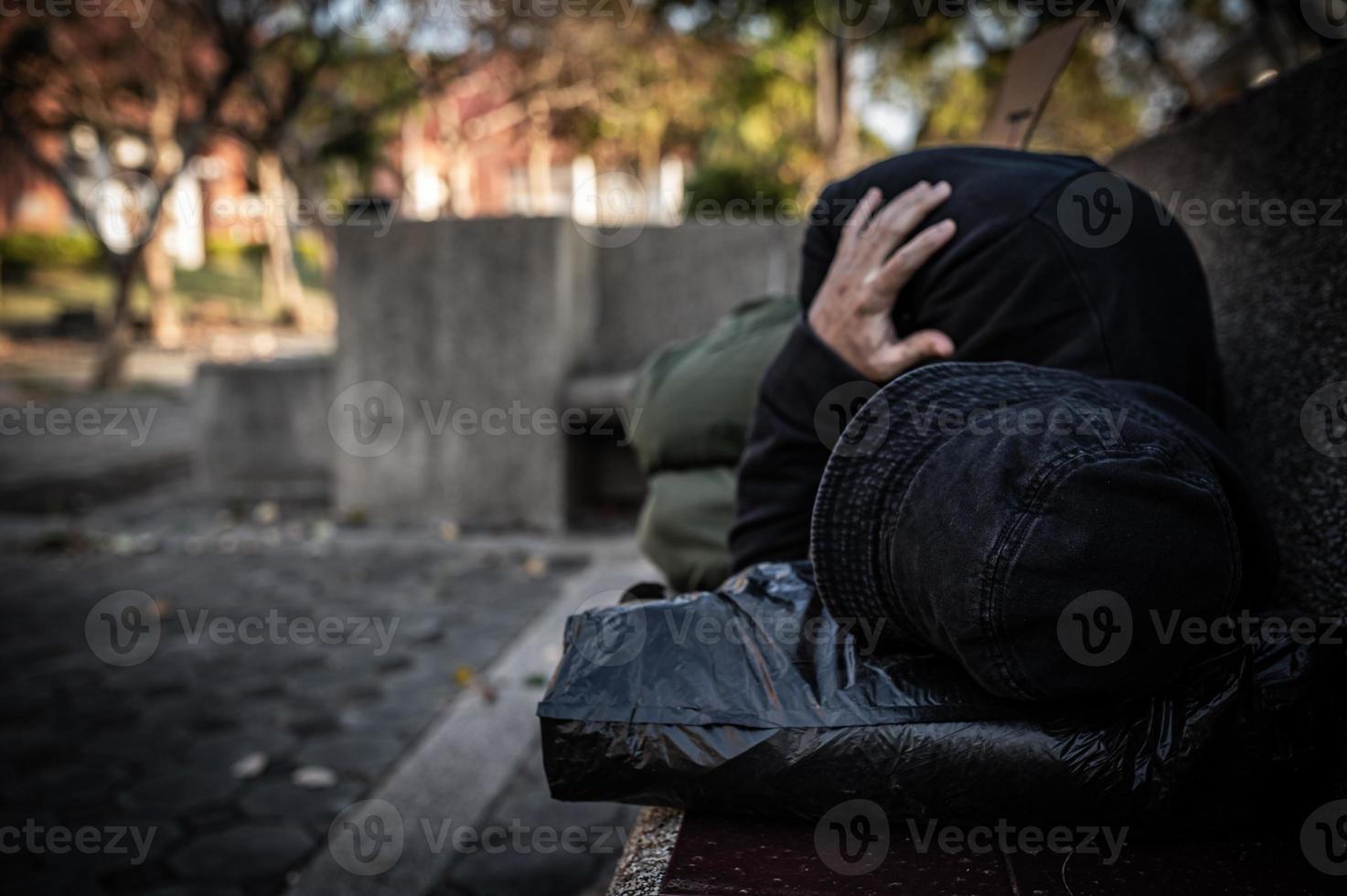 un hombre asiático no tiene hogar en la calle lateral, un extraño tiene que vivir solo en la calle porque no tiene familia. foto