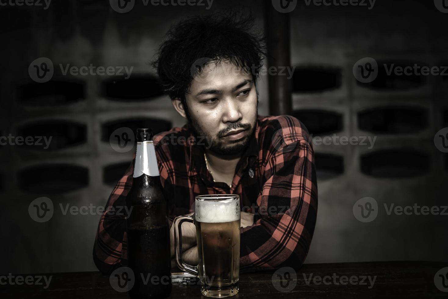 hombre asiático bebe vodka solo en casa por la noche, gente de tailandia, concepto de borracho de hombre estresado foto