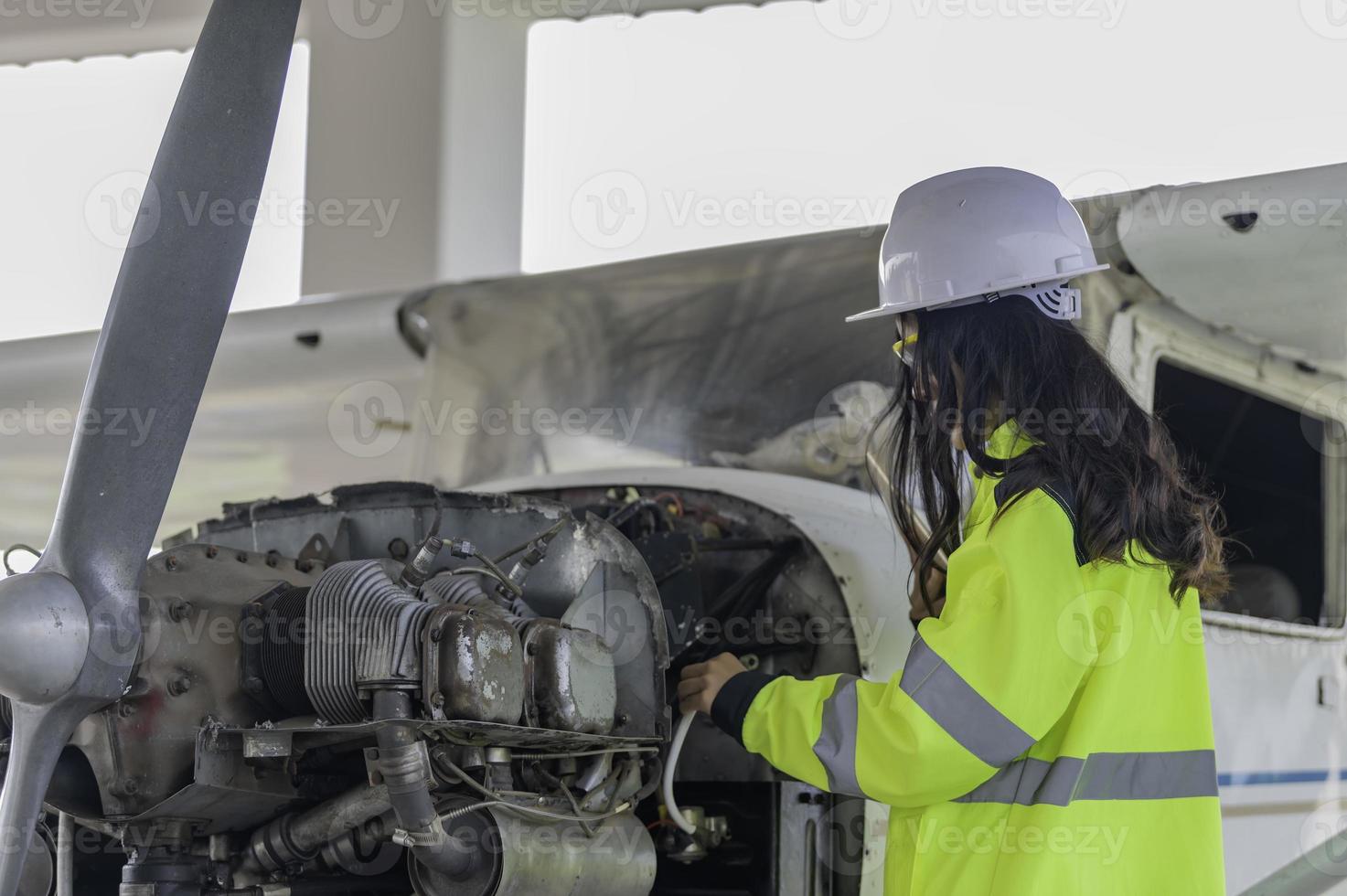 Technician fixing the engine of the airplane,Female aerospace engineering checking aircraft engines,Asian mechanic maintenance inspects plane engine photo