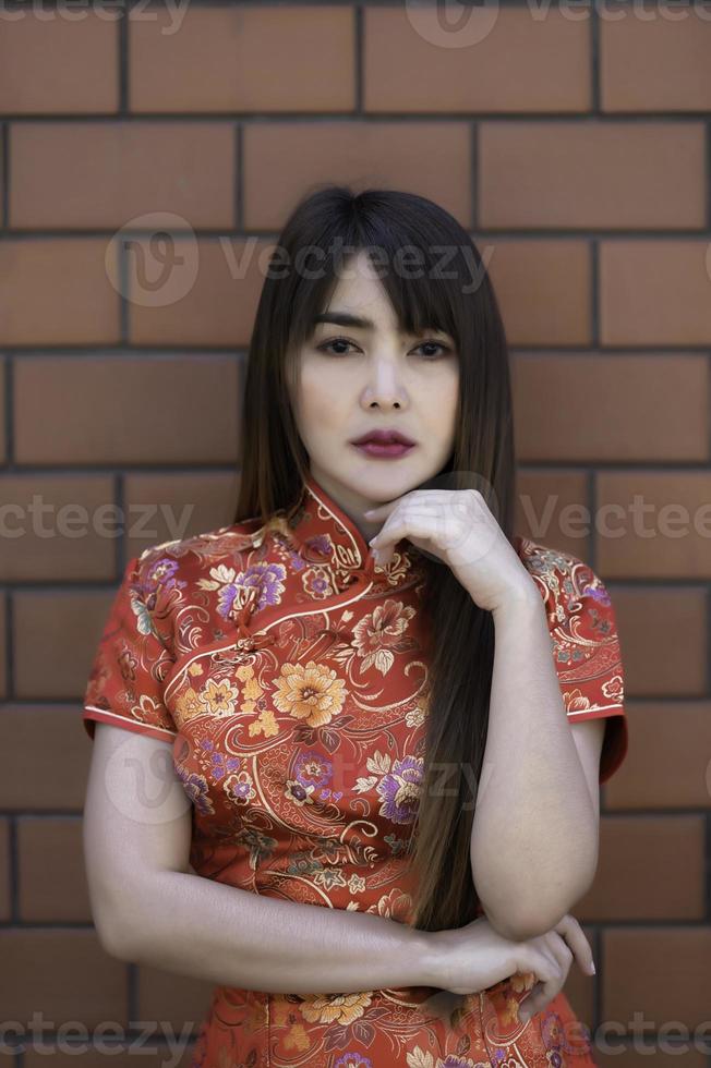 retrato hermosa asiático mujer en cheongsam vestido,tailandia gente feliz chino nuevo año concepto,feliz asiático dama en chino tradicional vestir foto