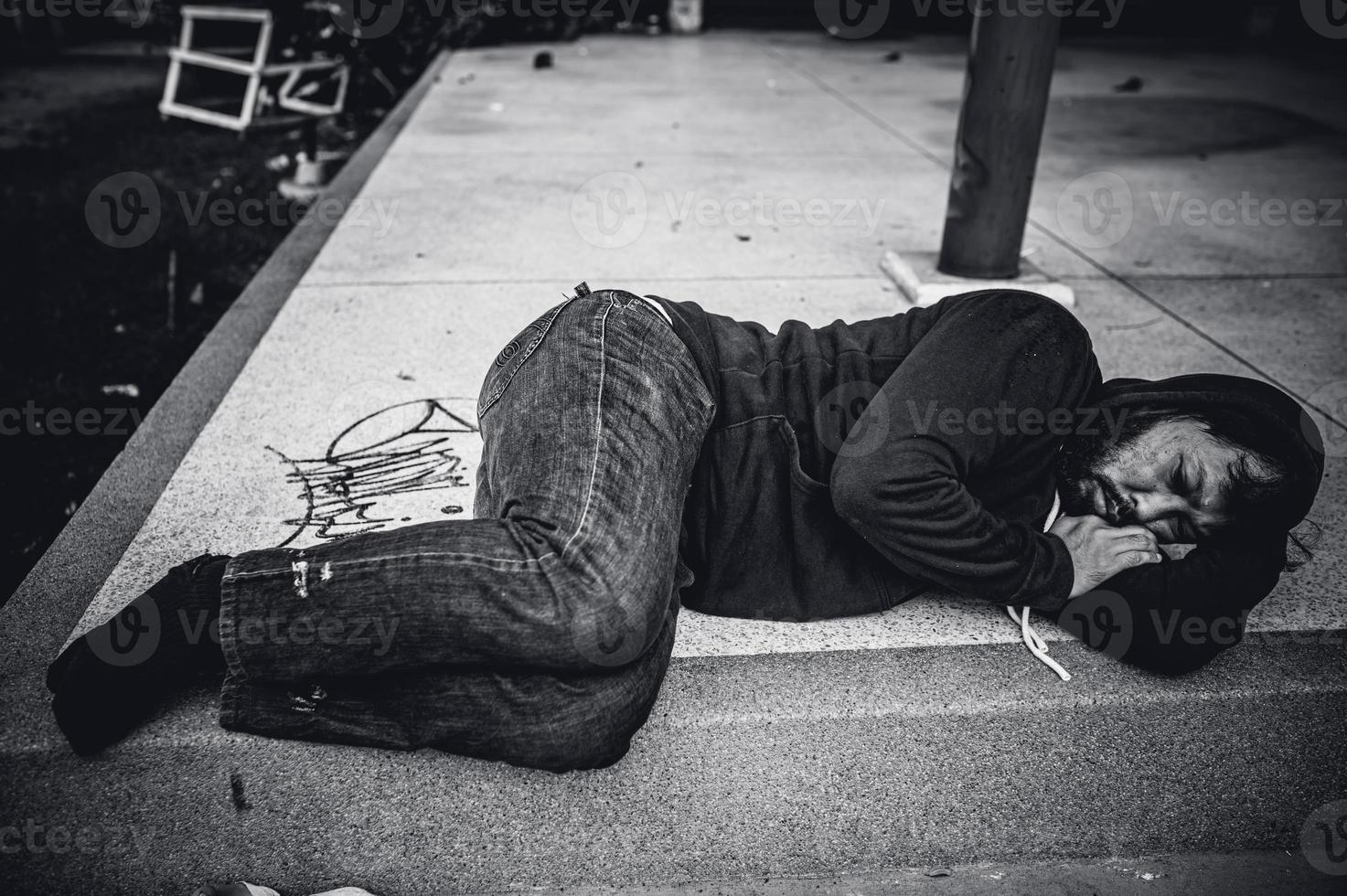 un hombre asiático no tiene hogar en la calle lateral, un extraño tiene que vivir solo en la calle porque no tiene familia. foto