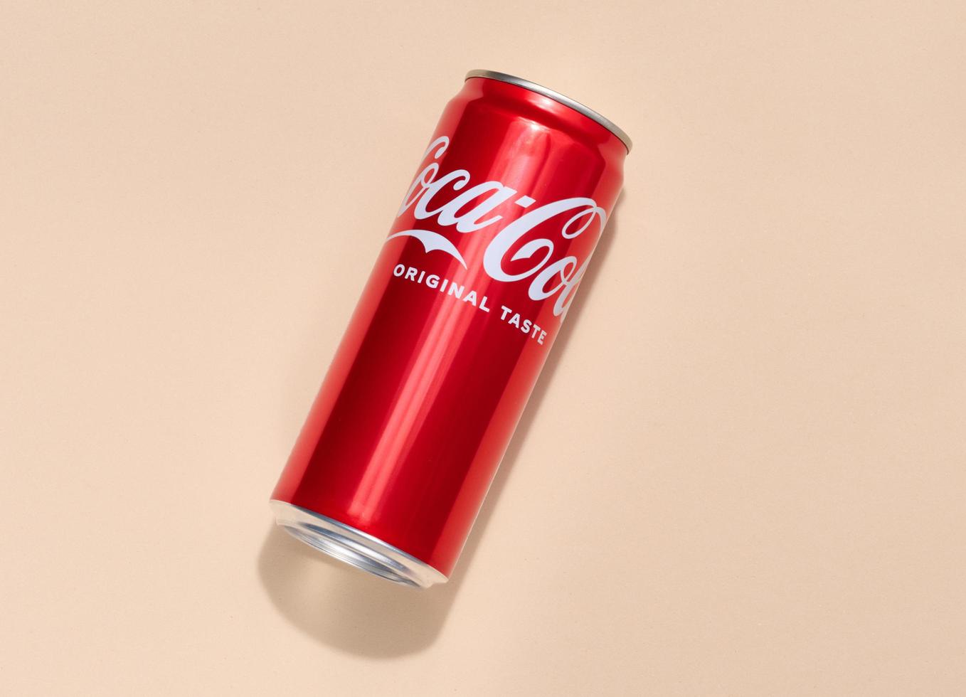 Ukraine, Nikolaev - March 25, 2023 Tin can with Coca Cola drink on a beige background, top view photo