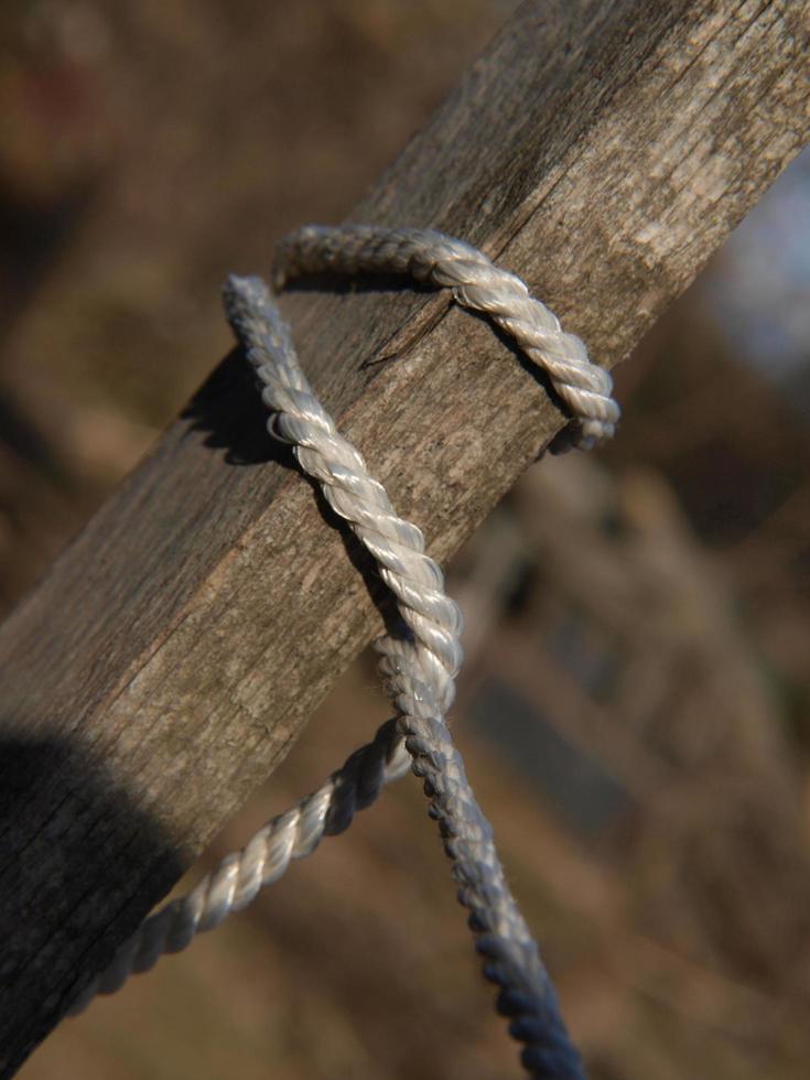 White rope tied around some wood detail photo