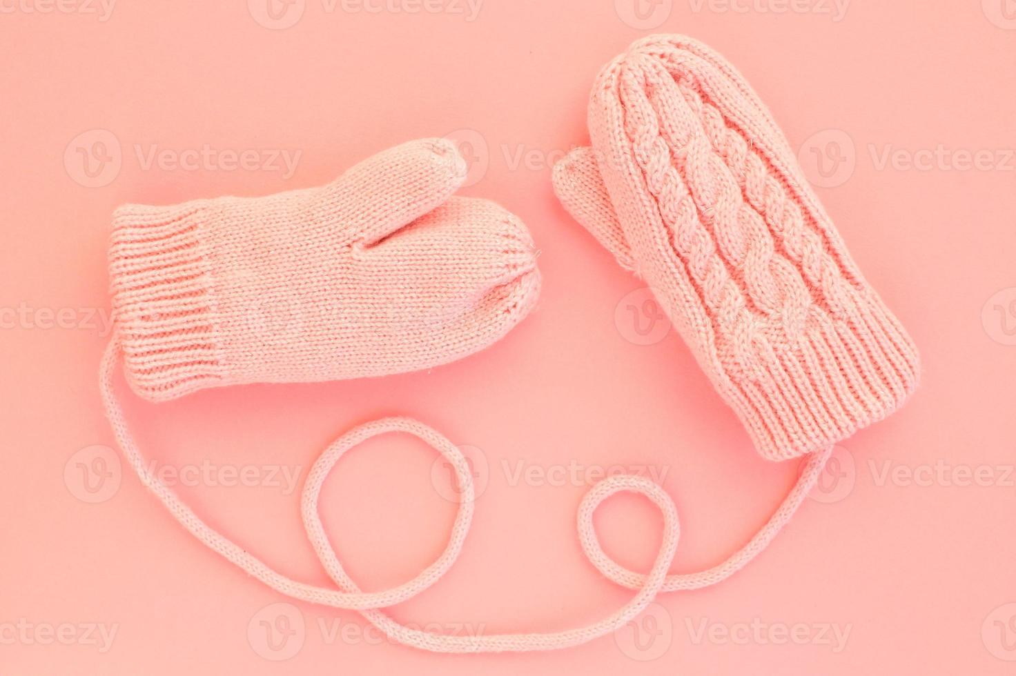 Close-up pink mittens and shaped of string on pink background. Lifestyle and warm feelings concept. Valentine day. Monocolor romantic pattern. Winter theme. Flat lay composition. Top view. Copy space photo