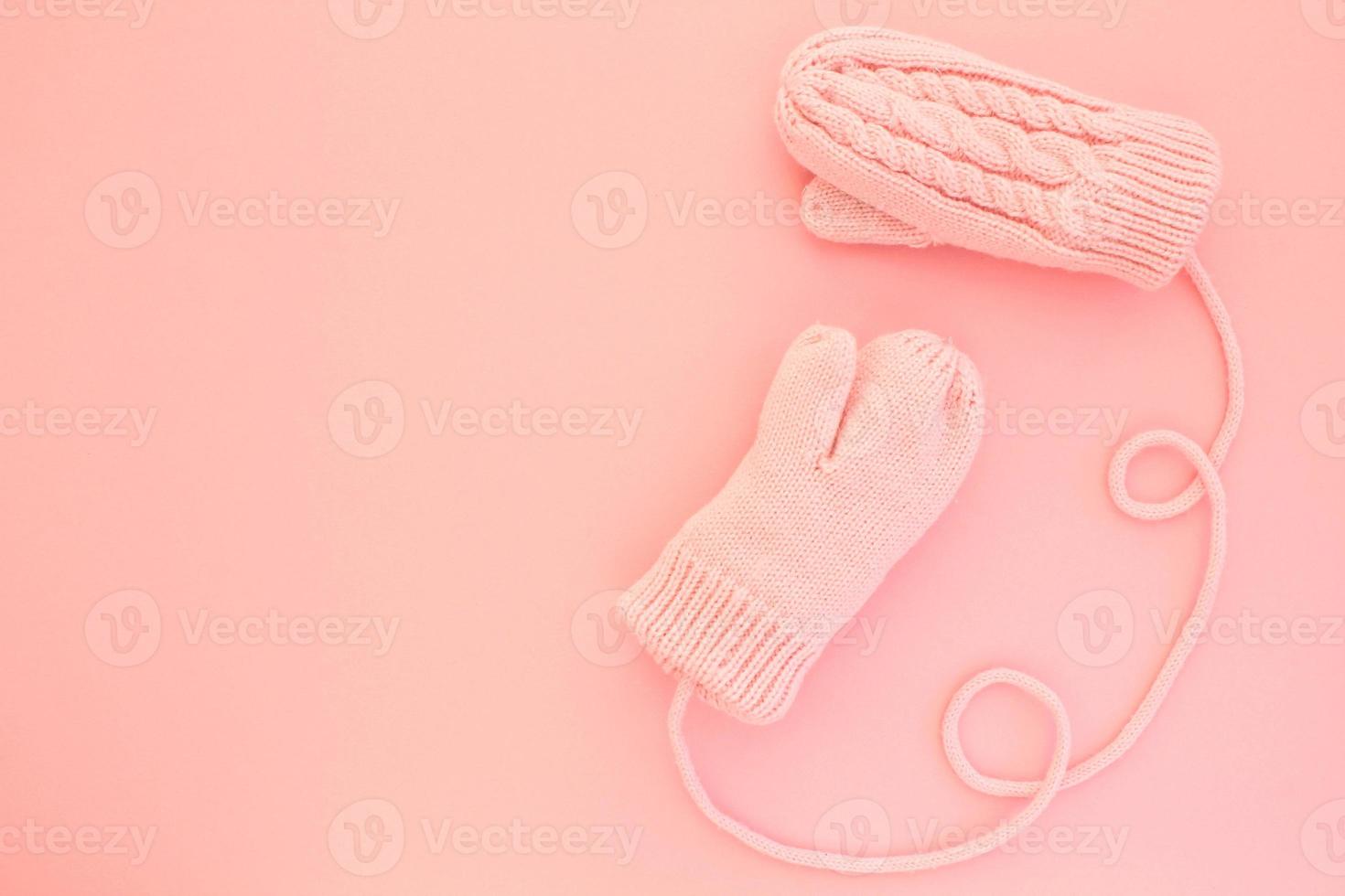 Close-up pink mittens and shaped of string on pink background. Lifestyle and warm feelings concept. Valentine day. Monocolor romantic pattern. Winter theme. Flat lay composition. Top view. Copy space photo