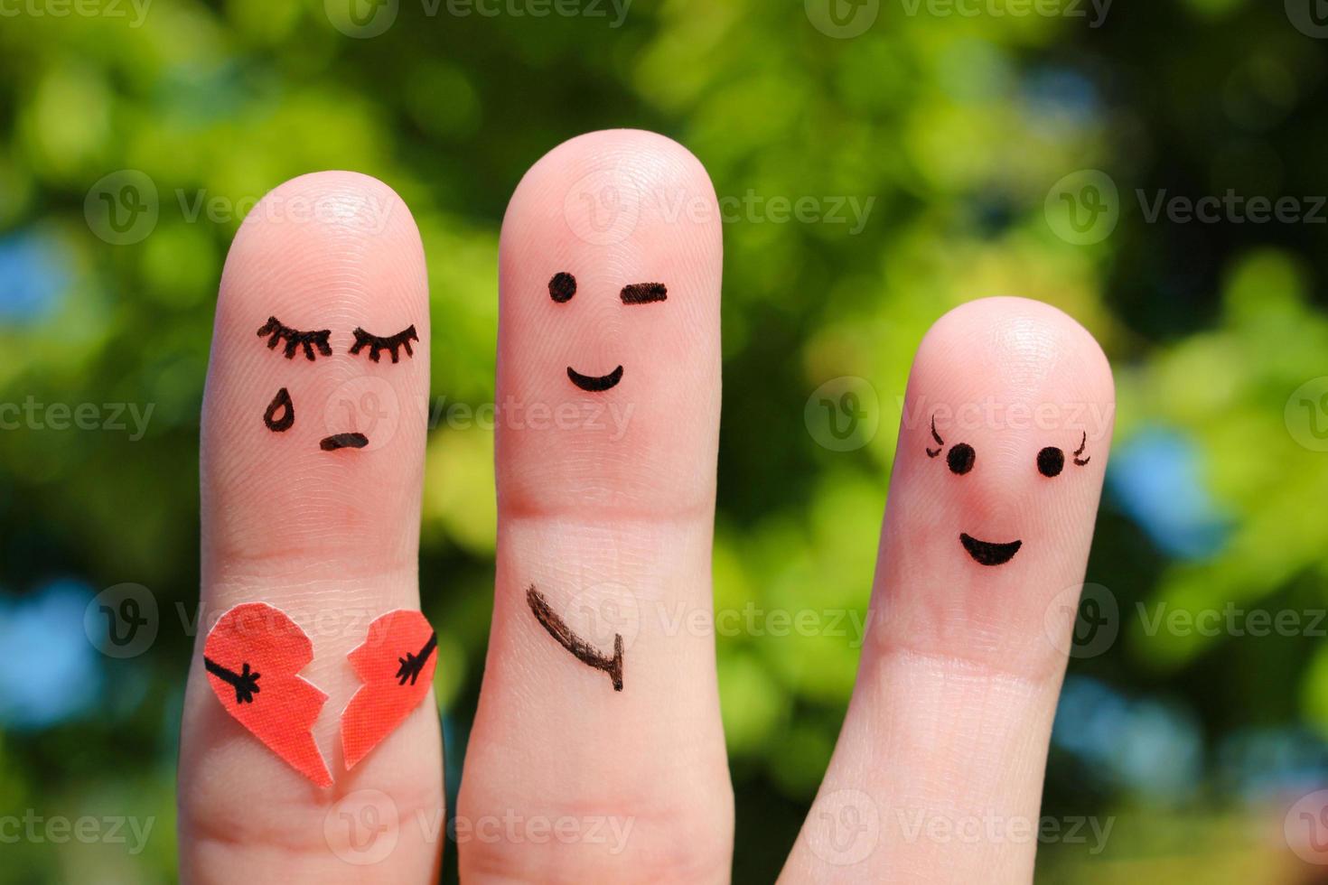 Finger art of people. Man flirts with woman. Other girl is holding broken heart. Concept of cheating in relationship. photo