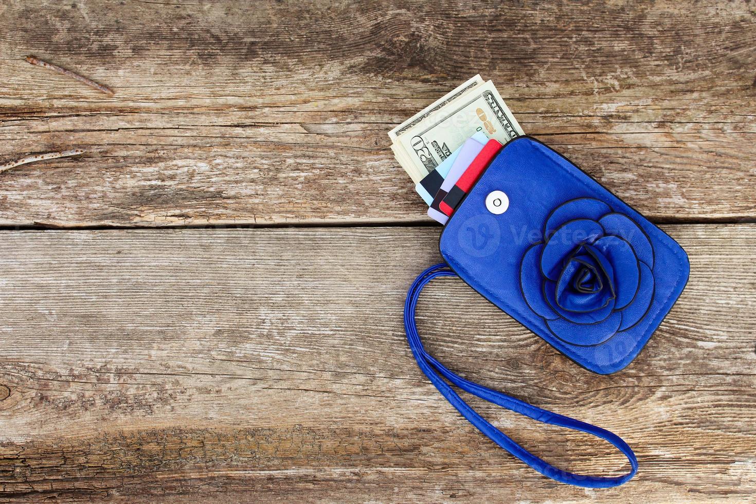 Credit card and dollars in wallet on wooden background. Top view. photo