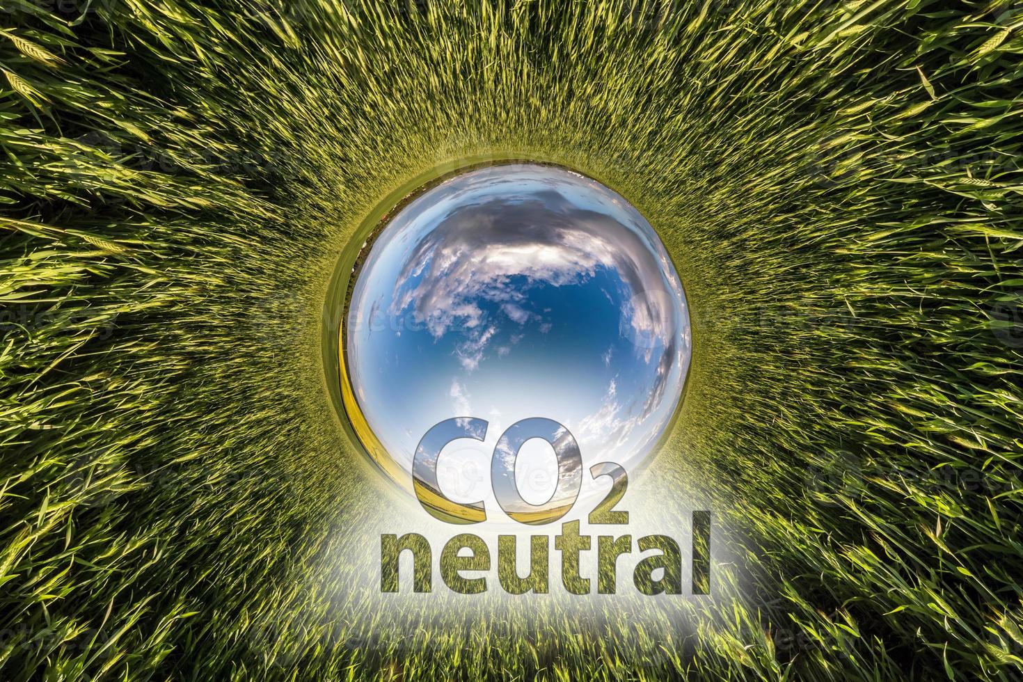 CO2 Neutral text concept image against blue little planet in green grass background photo