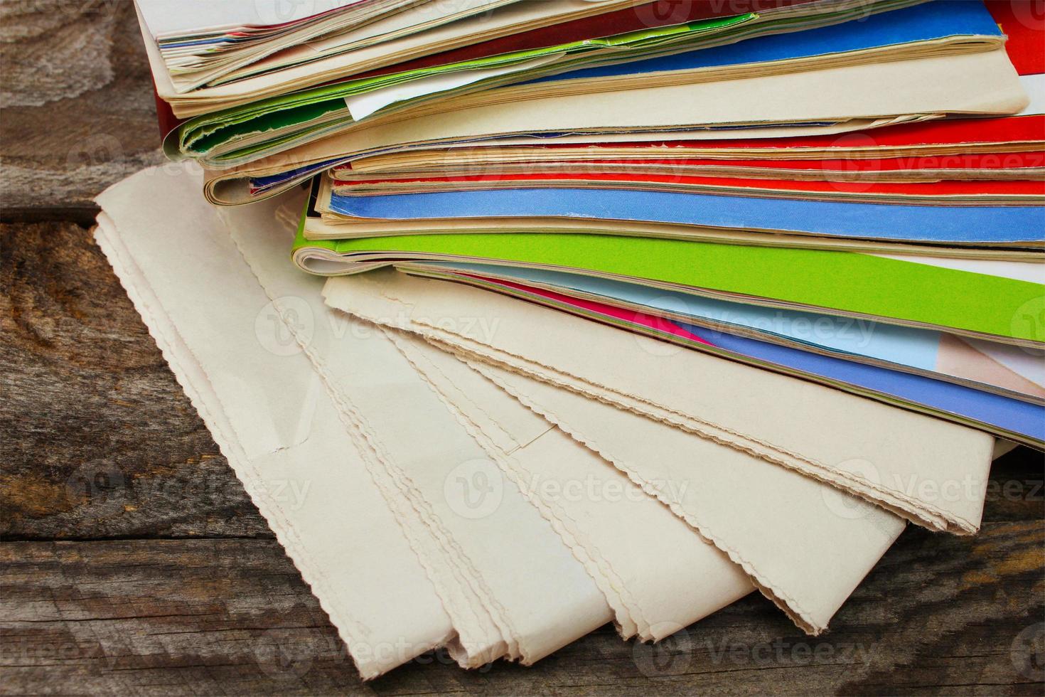 Newspapers and magazines on old wood background. Toned image. photo