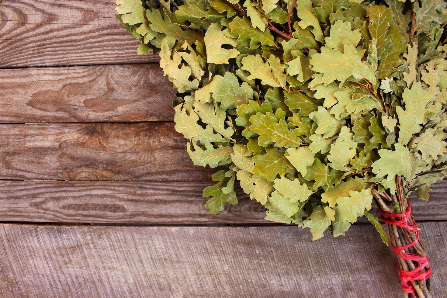 Oak broom for a bath on wooden background. photo