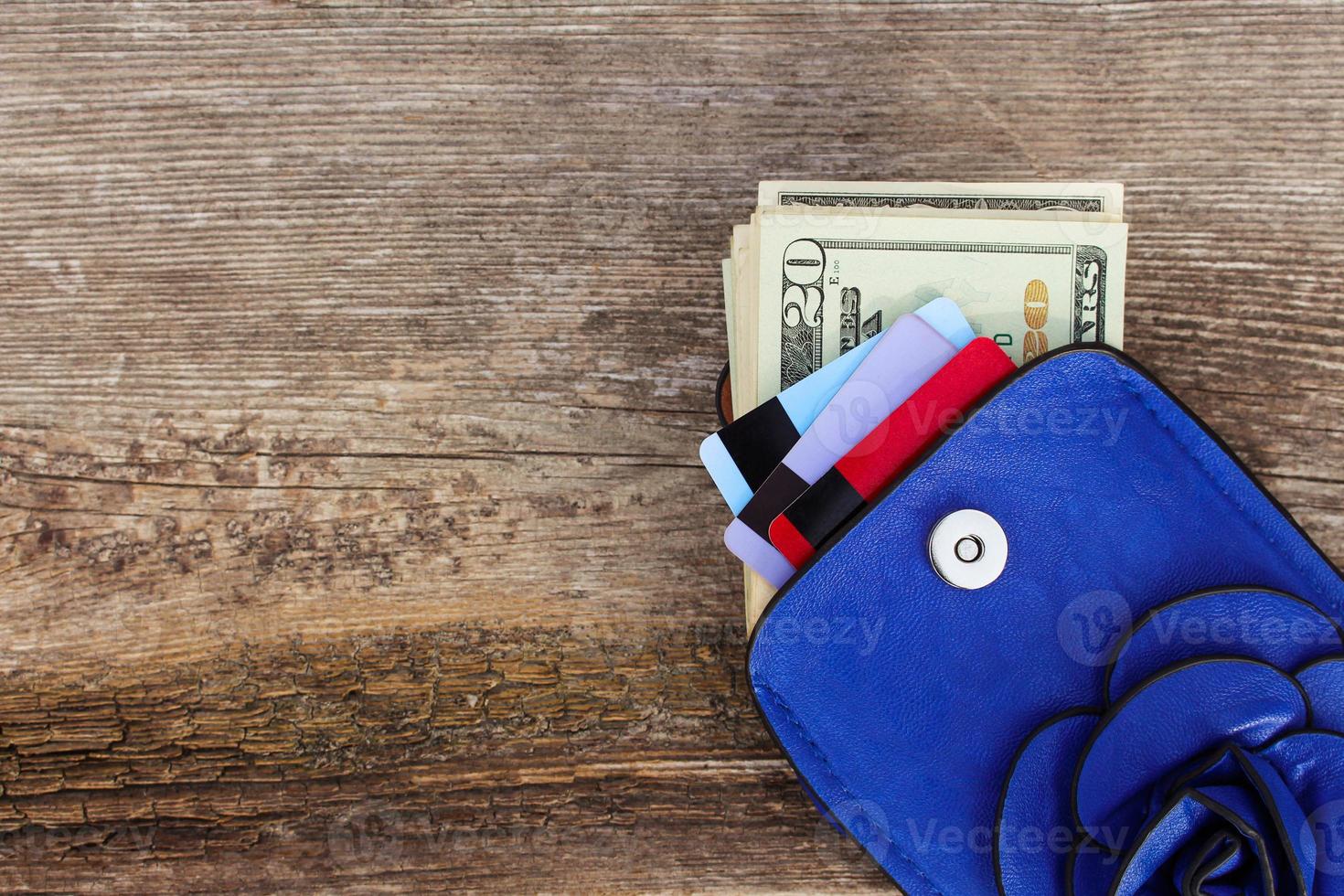 Credit card and dollars in wallet on wooden background. Top view. photo