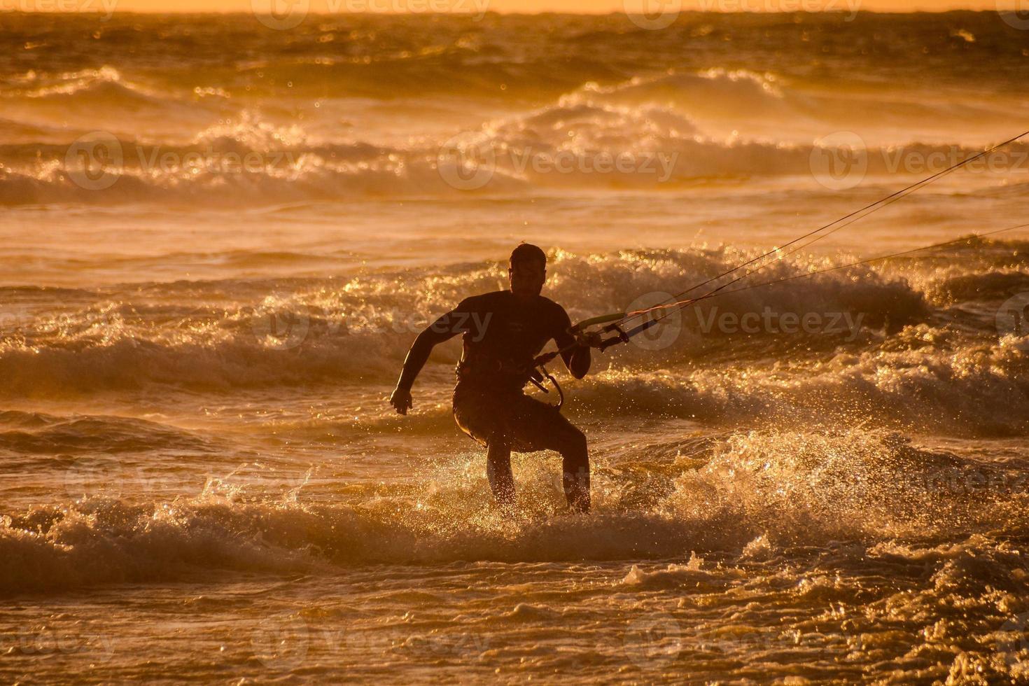 kitesurfer a puesta de sol foto