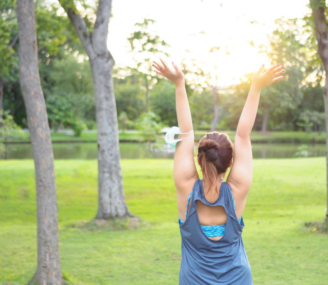 Portrait beautiful Asian woman in sportswear, standing with her back, stretching before exercising outdoor in park  morning to achieve healthy lifestyle. healthy  warming up photo