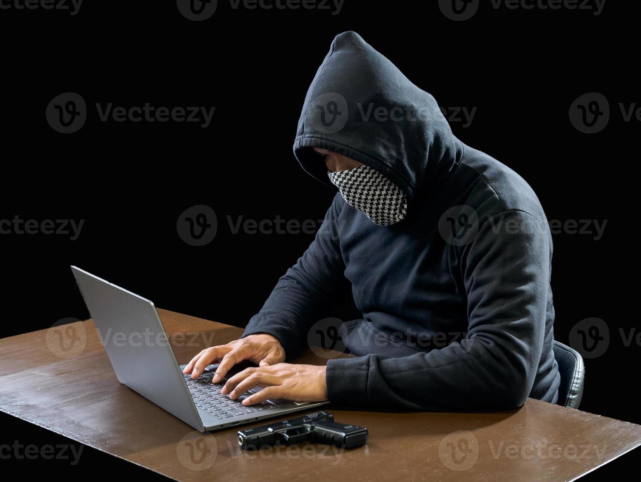 Hacker spy man one person in black hoodie sitting on a table looking computer laptop used login password attack security to circulate data digital in internet network system, night dark background. photo