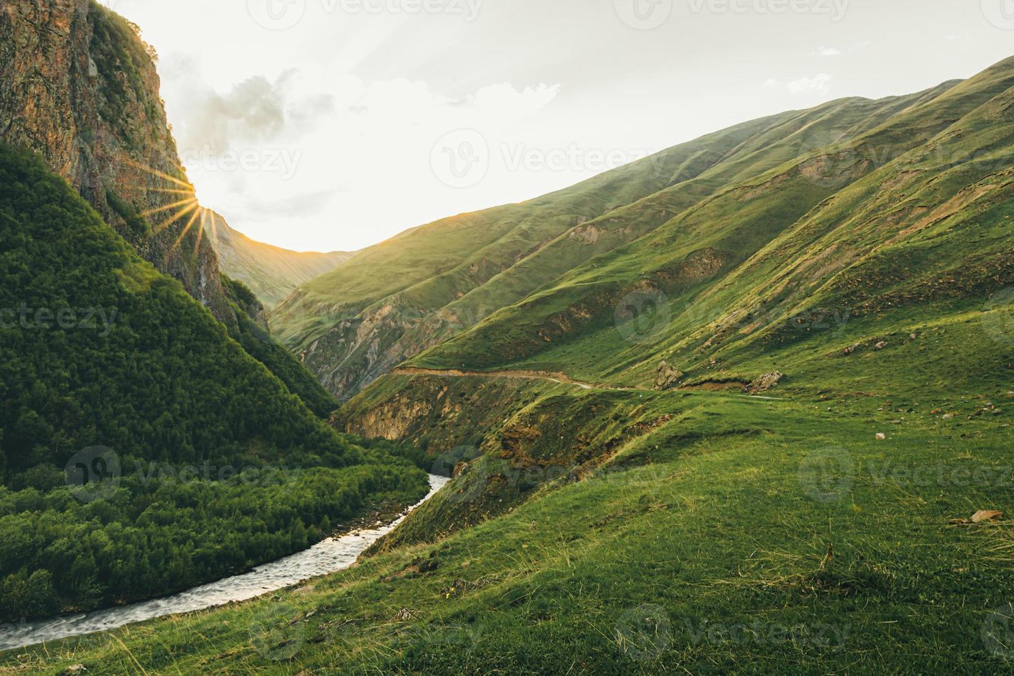 Scenic famous military road to Truso valley in Kazbegi national park. Hiking trail to Truso valley. Pristine caucasus mountains range. Sunset over mountains in Kazbegi. photo