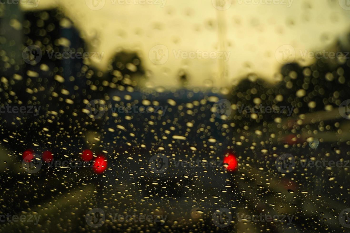 Night, drops on glass, red, yellow and blue lights from cars. Traffic jams. Bokeh background photo