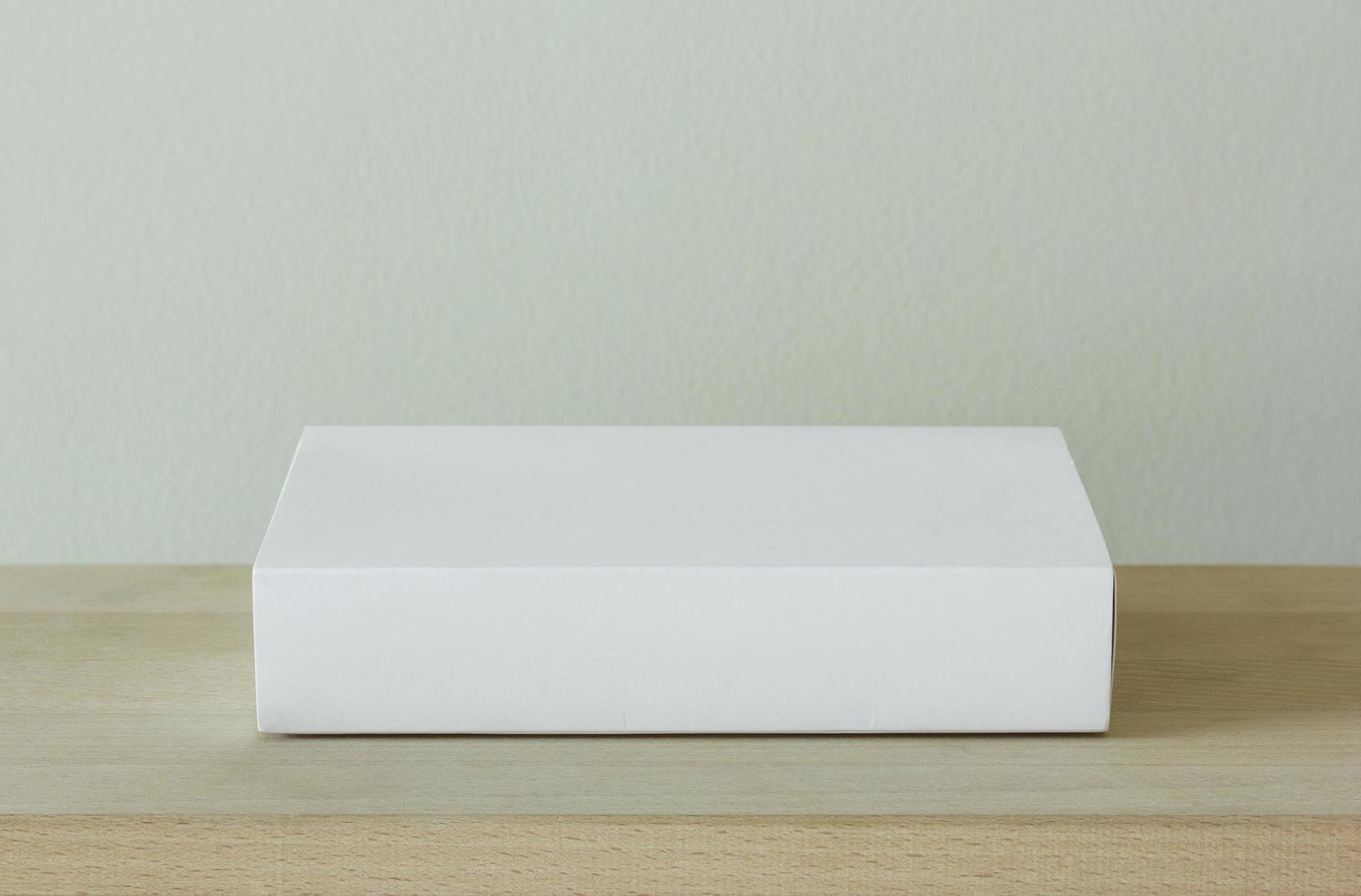 blank white cardboard package box mockup on wooden table photo