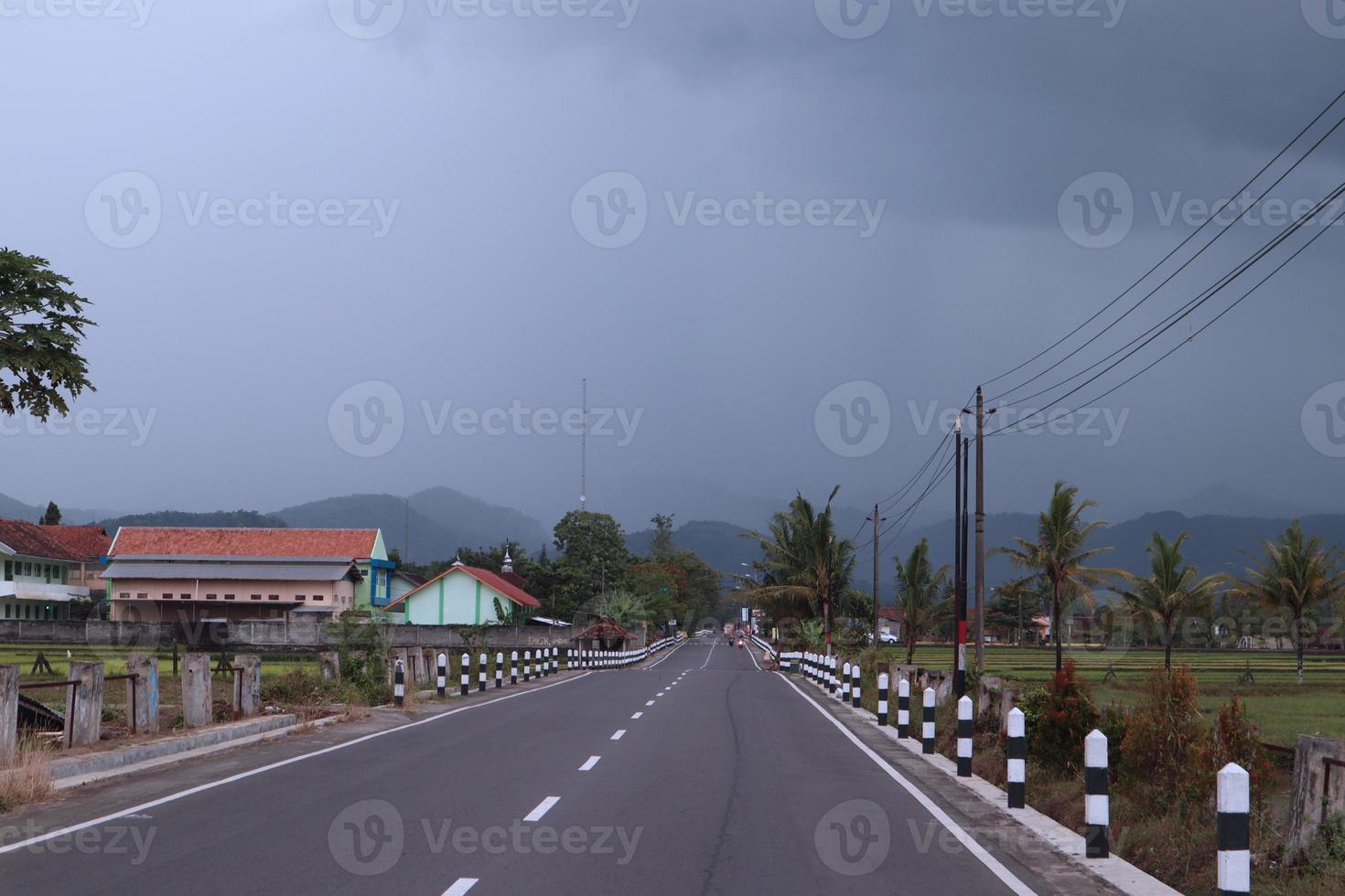 Country highway and green mountains natural landscape under the cloudy sky photo