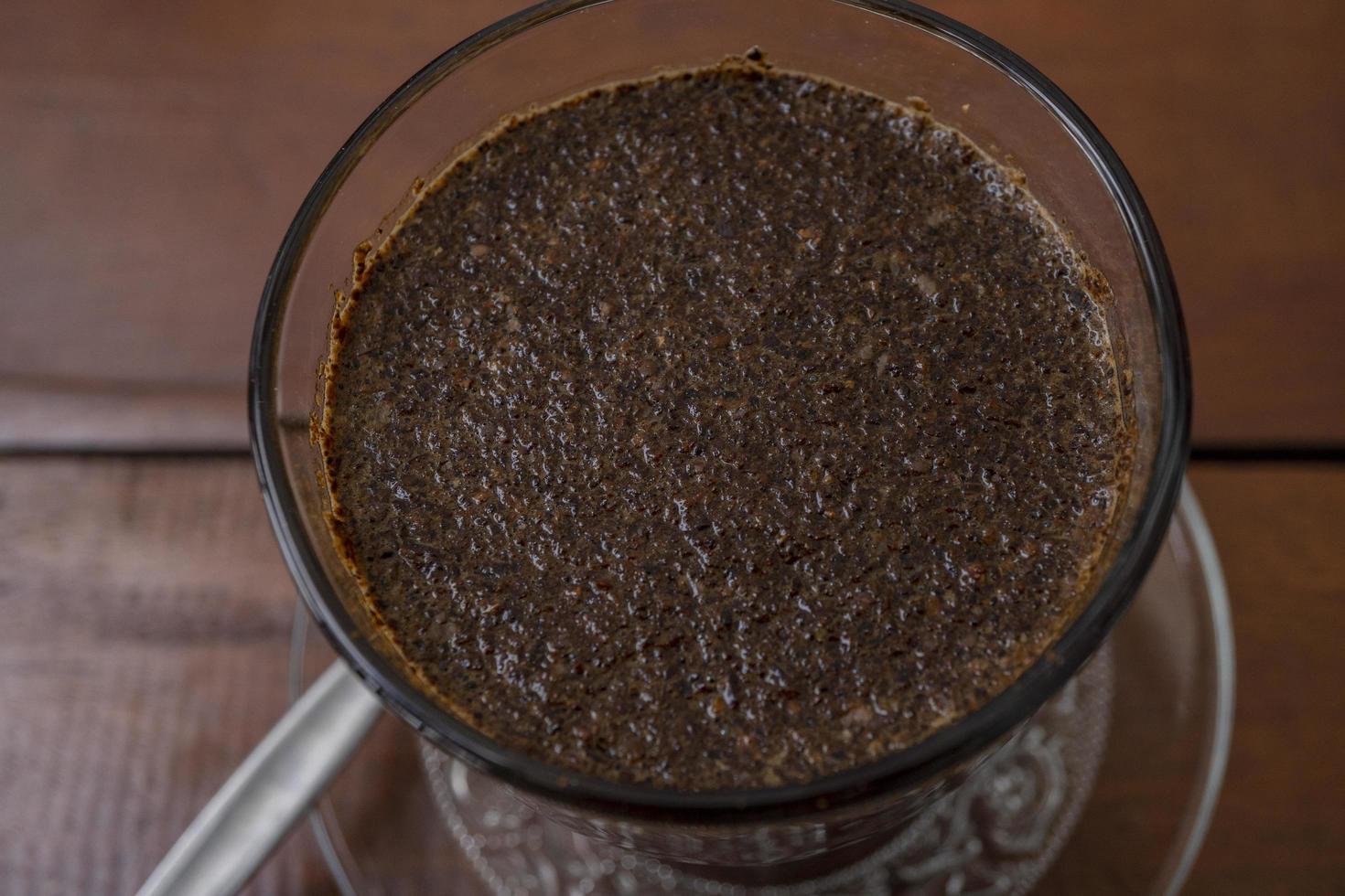 Close up photo a cup of arabica coffee with spoon from high angle. The photo is suitable to use for coffee shop background, menu poster and coffee content media.